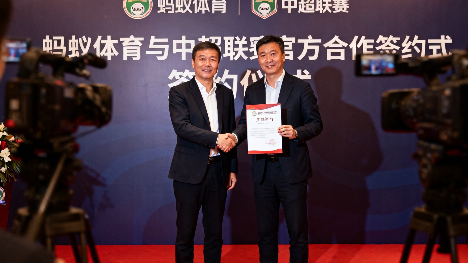 蚂蚁体育与中超联赛官方合作签约仪式现场照片，双方代表握手并展示合作协议。